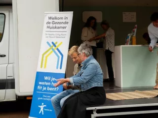 Twee mensen zittend bij de Gezonde Huiskamer met elkaar in gesprek